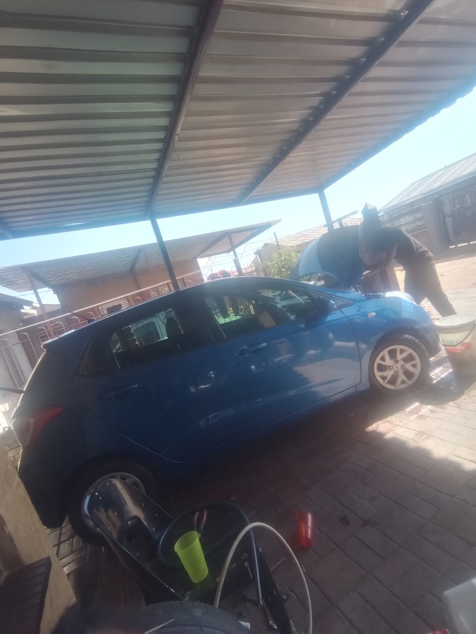 Thapelo performing engine work on a vehicle at his workspace